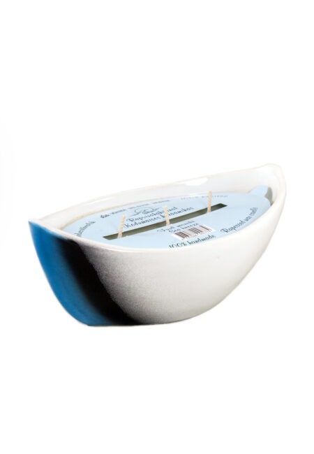 Scented candle in a ceramic boat